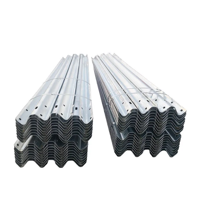 Stacks of galvanized W-beam guardrail rails showing two-wave profiles and bolt holes